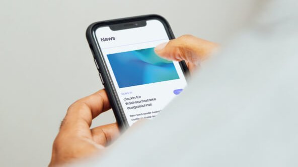 Person schaut auf einen Handy Bildschirm auf die Webseite Person schaut auf einen Handy Bildschirm auf die Webseite